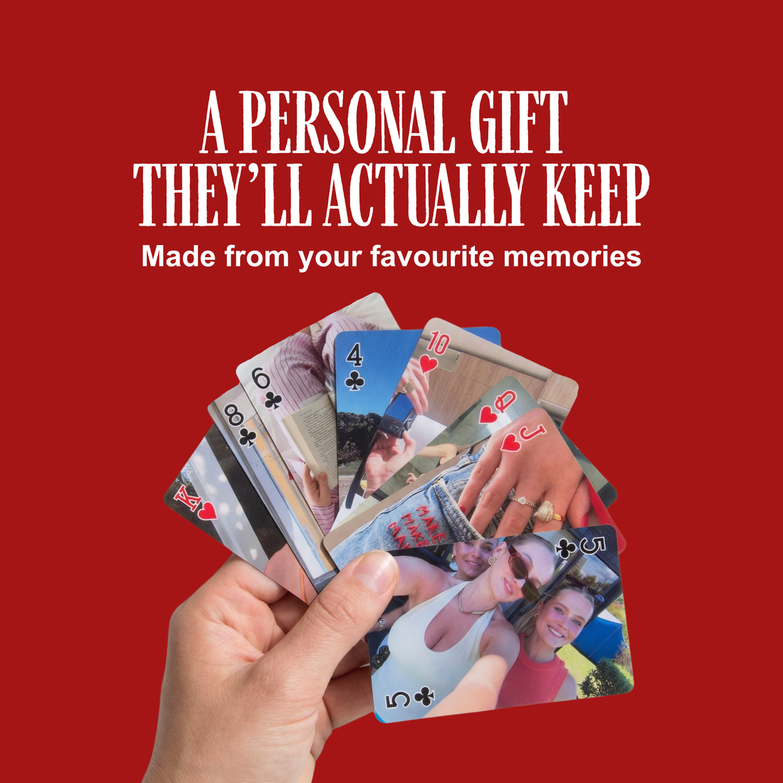 Hand holding a fan of personalised photo playing cards on a red background
