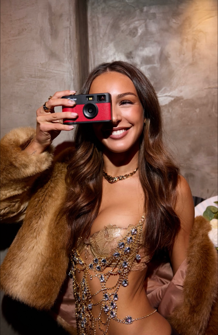 A woman taking a photo with the red Mimies camera