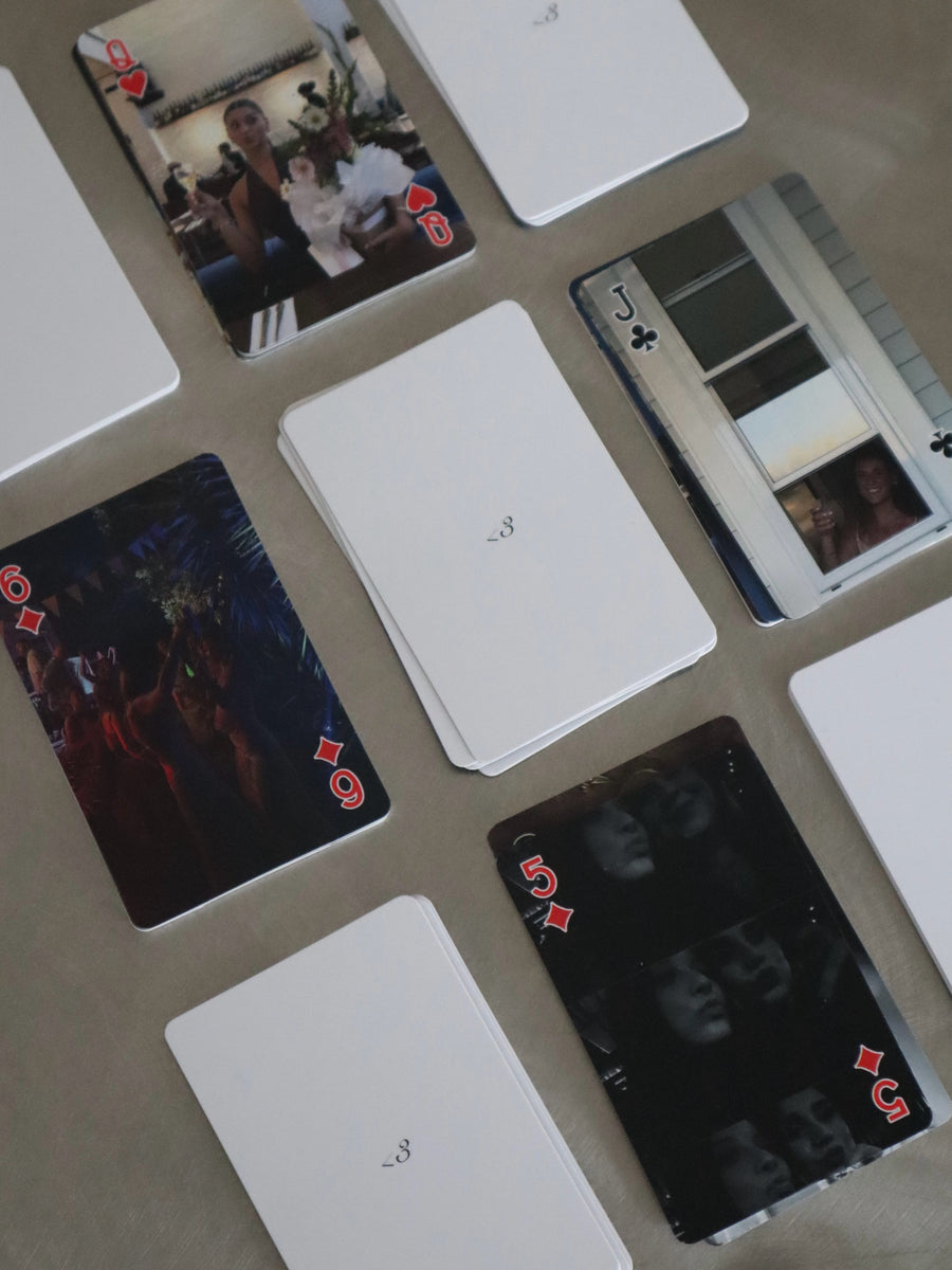 Personalised photo playing cards and card backs laid out on a table