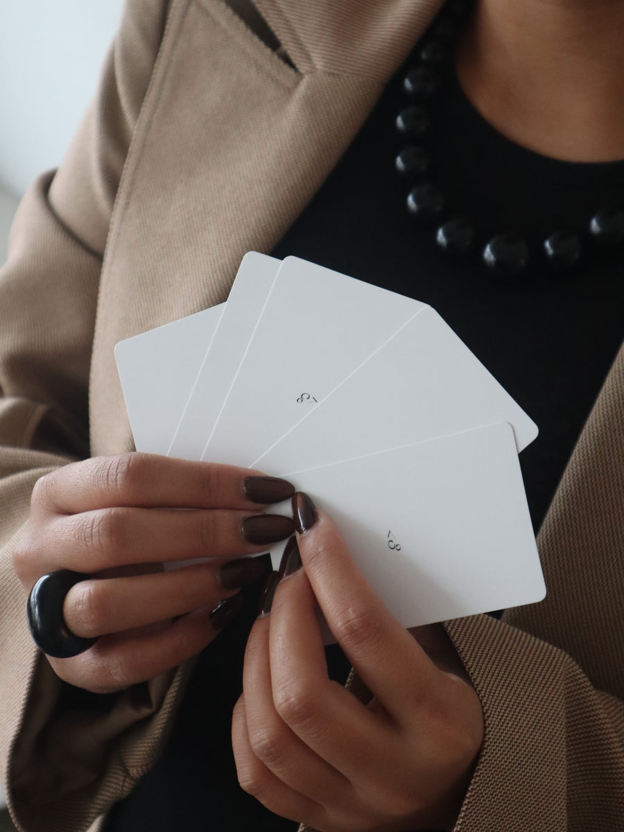 Hands fanning the backs of a Mimies playing card deck